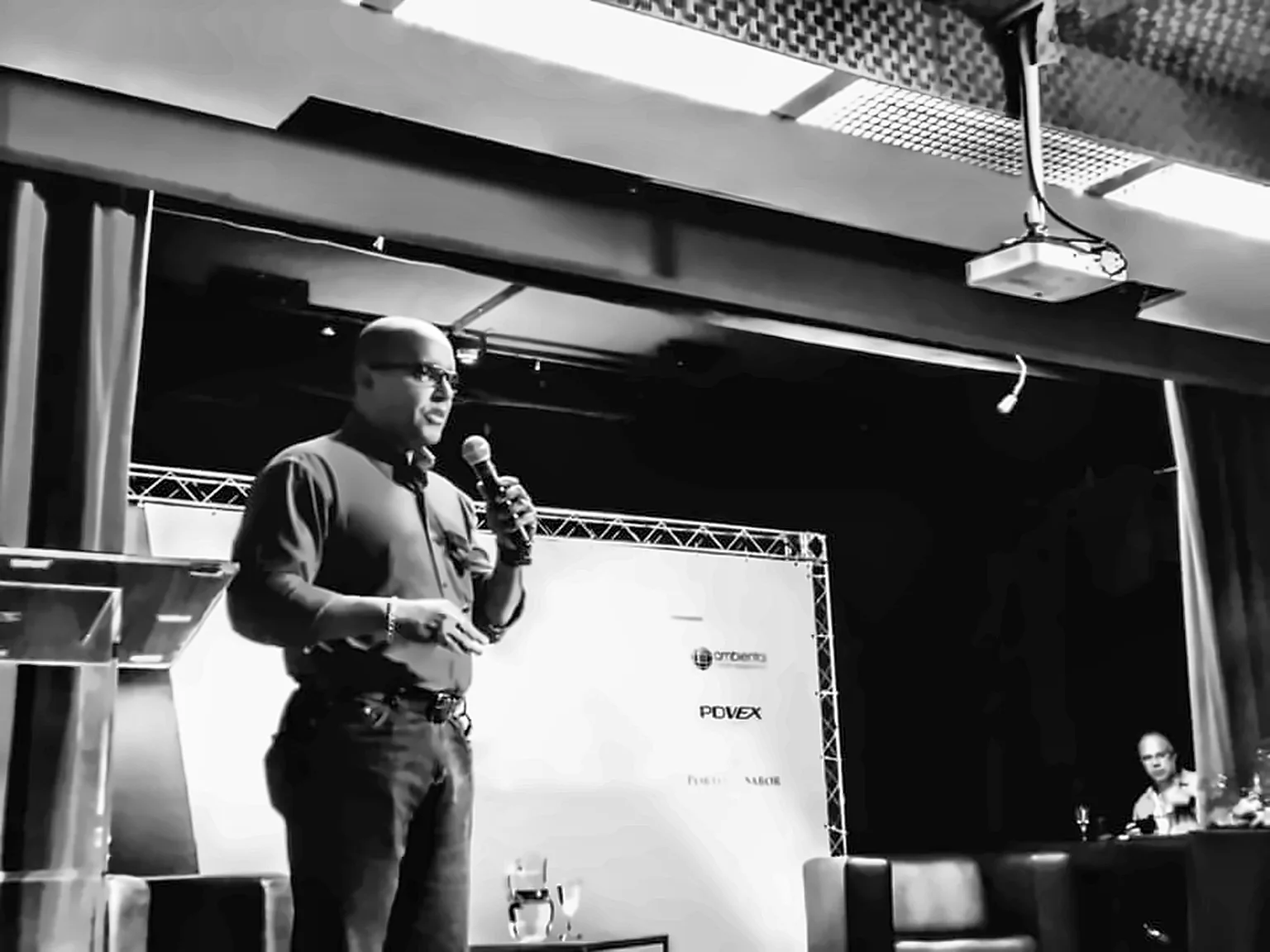 Luetil Neto se apresenta em palco de evento, em foto preto e branco